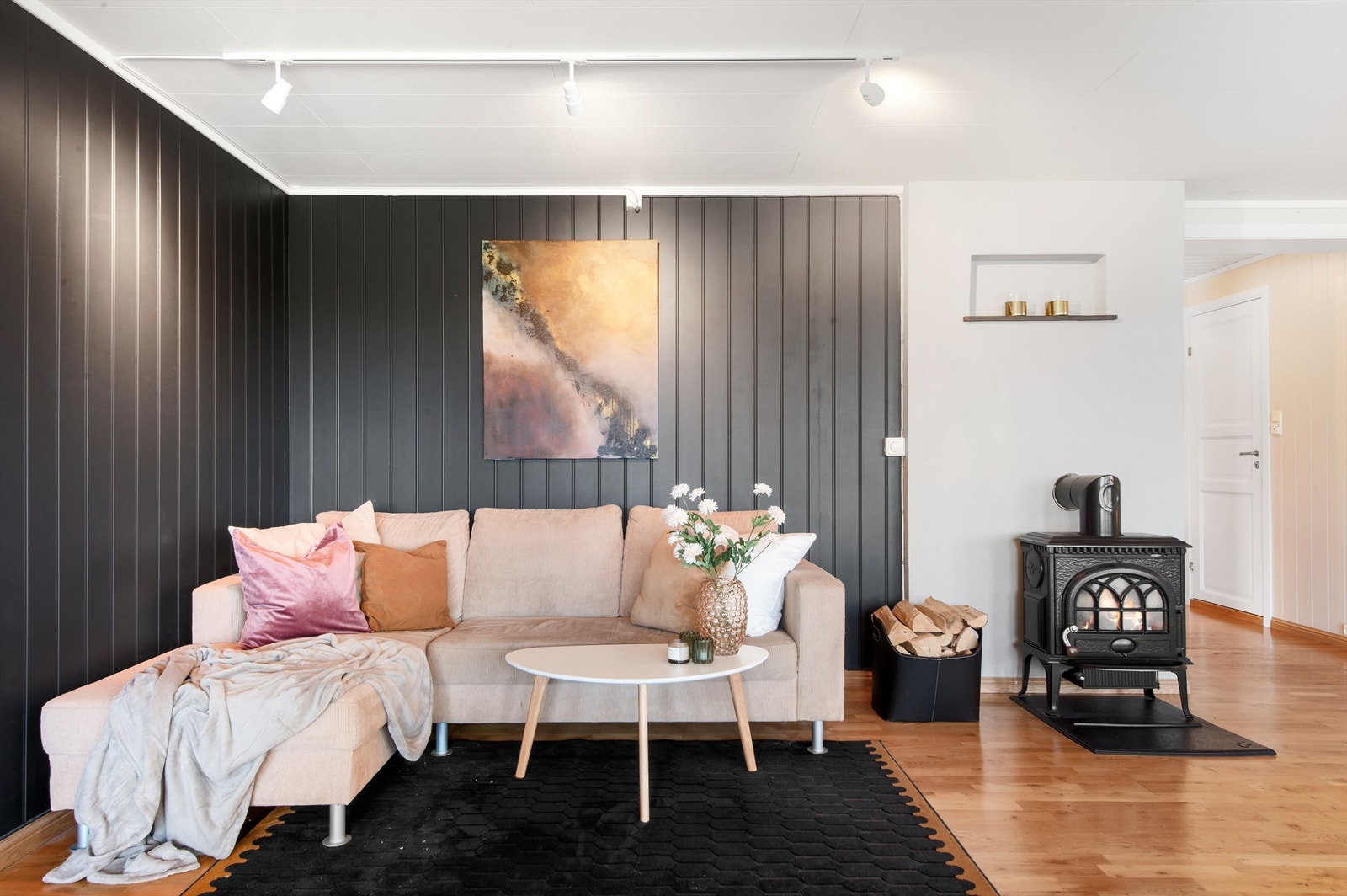 Sofakroken er lun og tilbaketrukket, med en mørk fondvegg som skaper en fin kontrast. Galleribilde