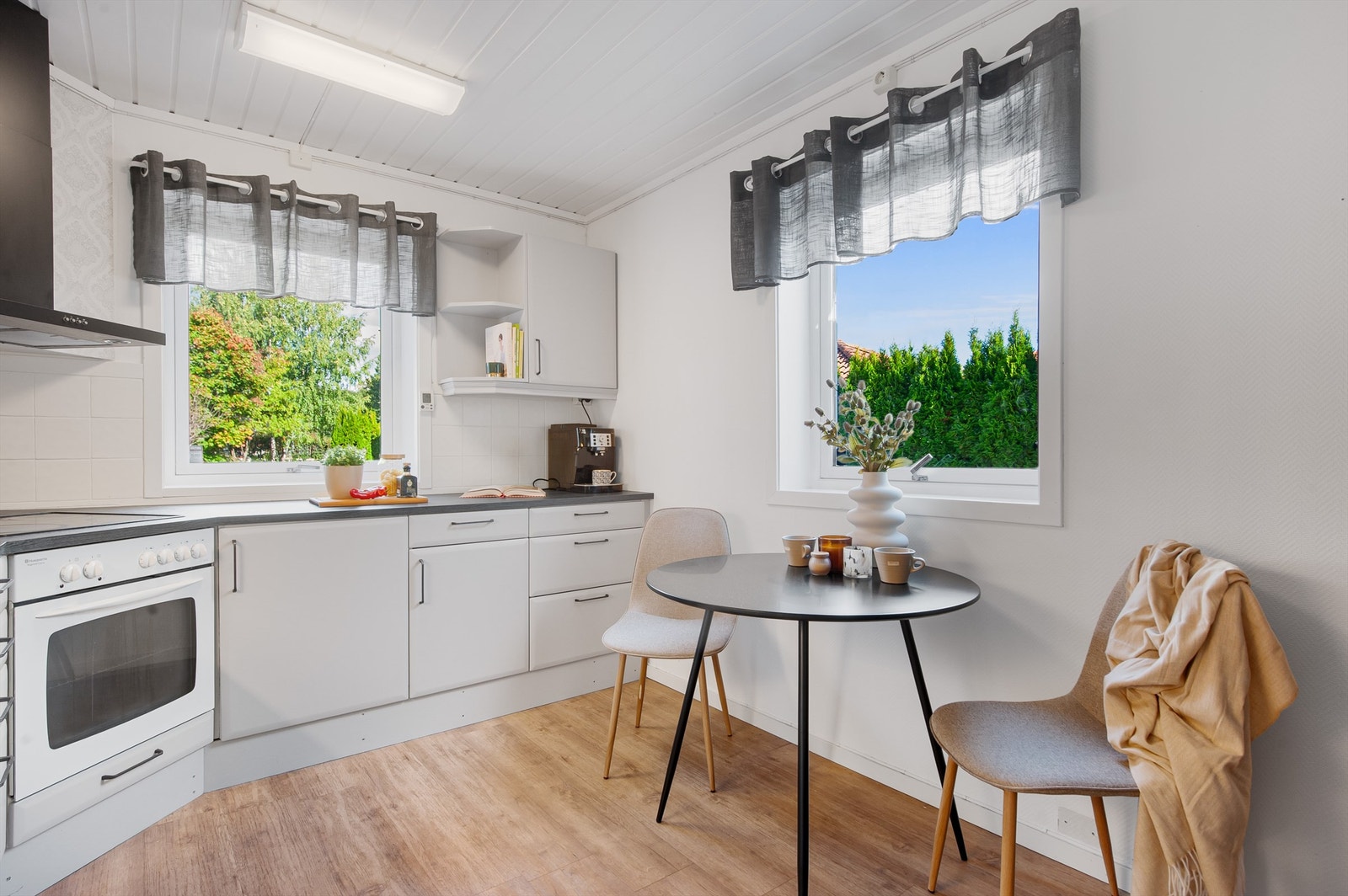 Kjøkkenet har en hyggelig spiseplass ved vinduet. Galleribilde