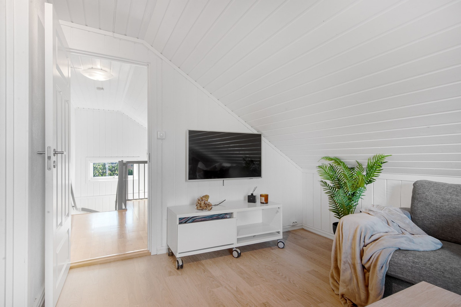 Skråtaket og panelkledde vegger og tak gir rommet en lun karakter. Galleribilde