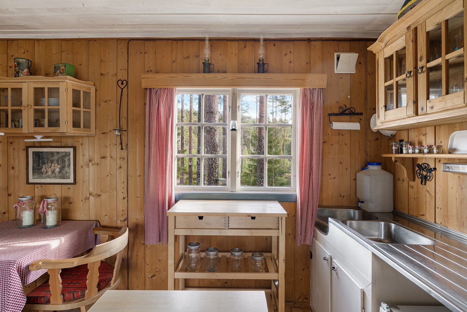 Kjøkkenet har enkel, plassbygd innredning med lyse fronter og laminatbenkeplater, samt benkebeslag med utslagsvask og oppvaskkum. Galleribilde