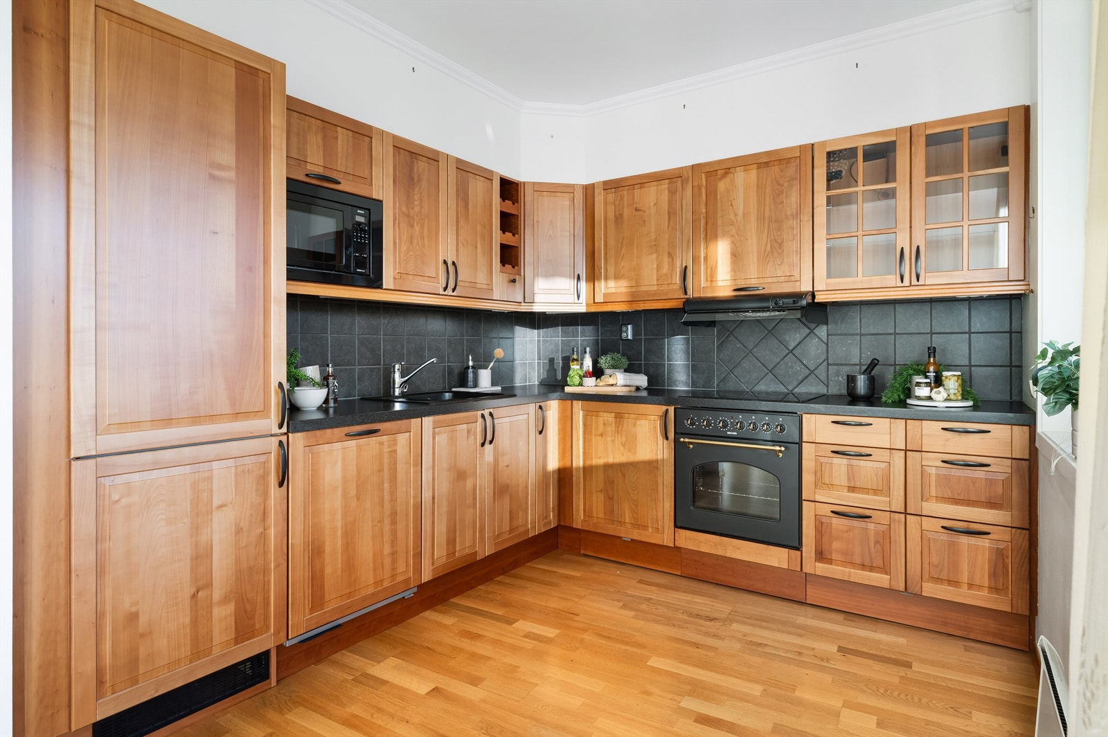 Kjøkkenet har profilerte fronter med sorte detaljer og ikke minst mye oppbevaringsplass. Galleribilde