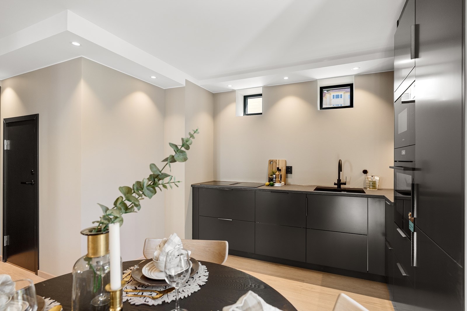 Dette har moderne, sorte fronter og laminat benkeplate. Kjøkkenet er ellers velutstyrt med integrerte hvitevarer som kjøl/fryseskap, oppvaskmaskin, induksjonstopp, mikrobølgeovn og stekeovn. Galleribilde