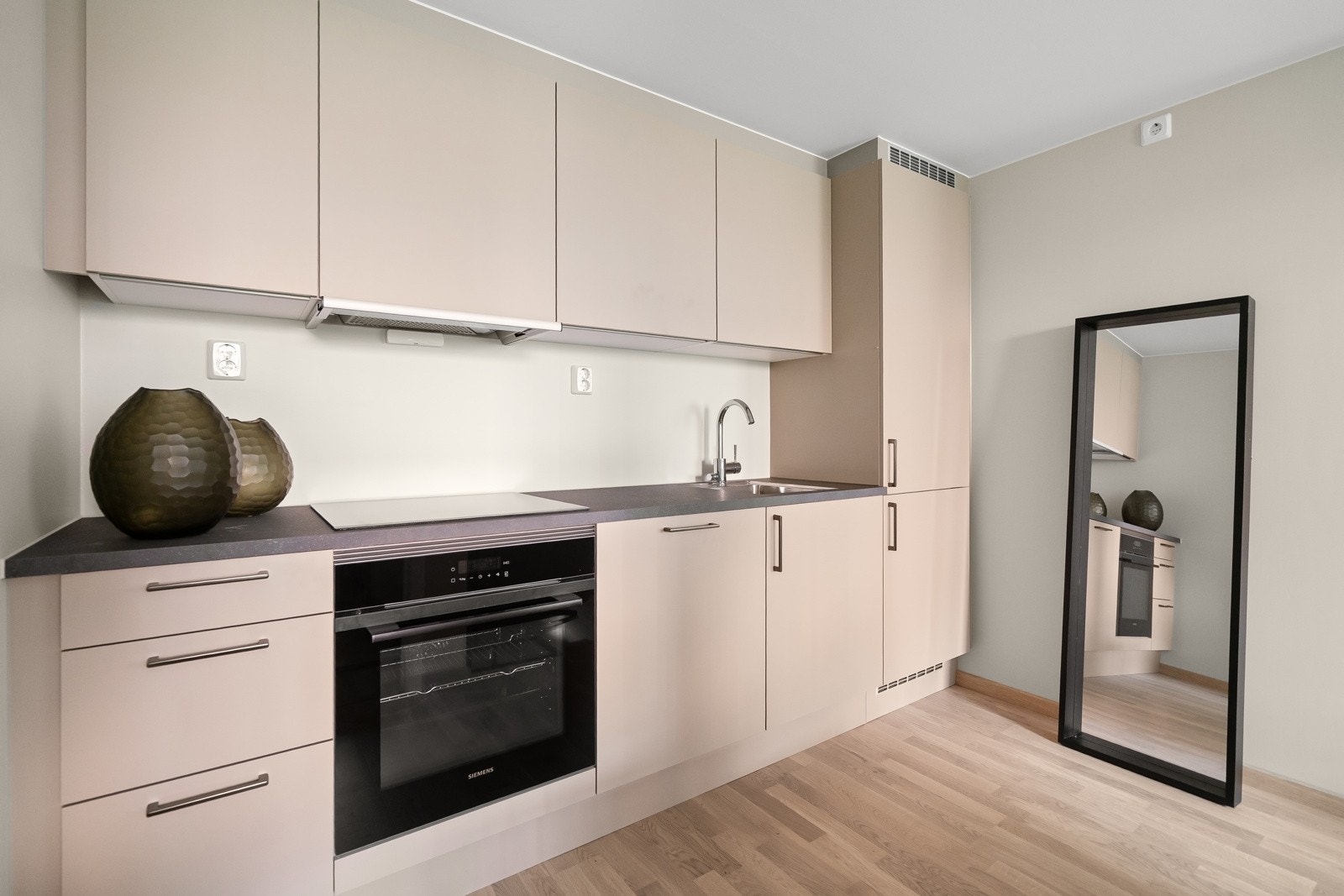 I en åpen løsning mot stuen finner du et stilrent, delikat HTH kjøkken. Integrerte hvitevarer som induksjonsovn med platetopp, kjøl/frys og oppvaskmaskin. Det er avtrekk fra ventilator via balansert ventilasjonsanlegg. Galleribilde