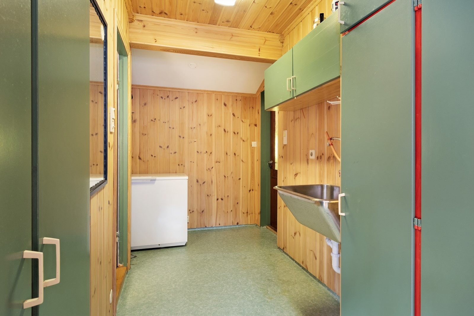 Vaskerommet har standard frå byggjeår og inneheld utslagsvask i stål og skåpinnreiing. Frå rommet er det direkte tilkomst ut til hage. Galleribilde