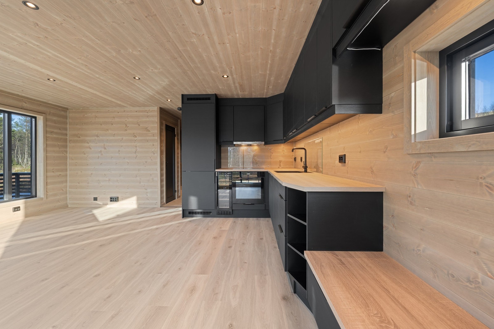 Kjøkkenet har smart benk med skuffer under. Vinskap og integrerte hvitevarer. Galleribilde