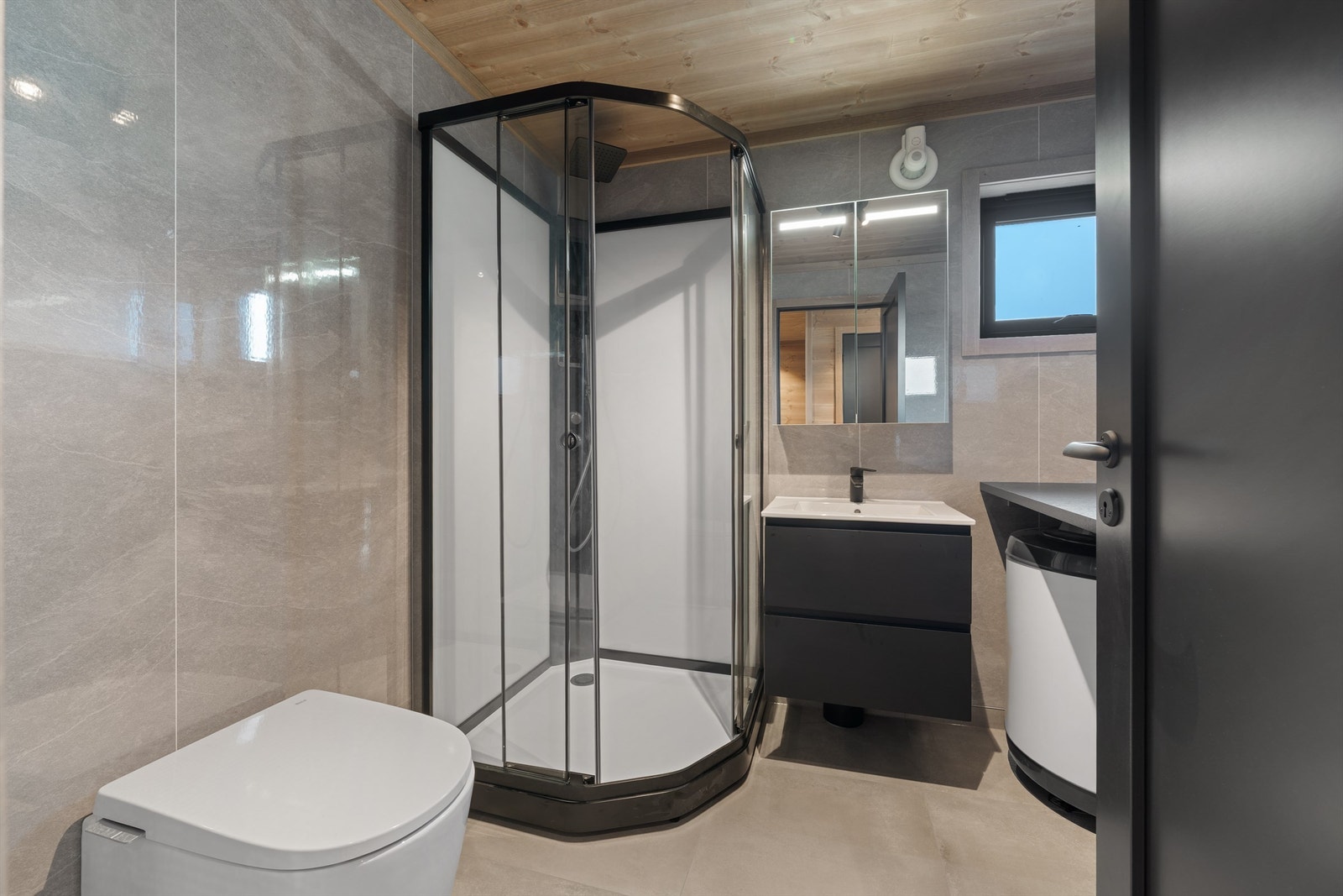 Bad vil få fliser på gulv samt våtromsplater på vegg. Ellers vil det være svart baderomsinnredning, dusjkabinett, vegghengt wc og opplegg til vaskemaskin. Galleribilde