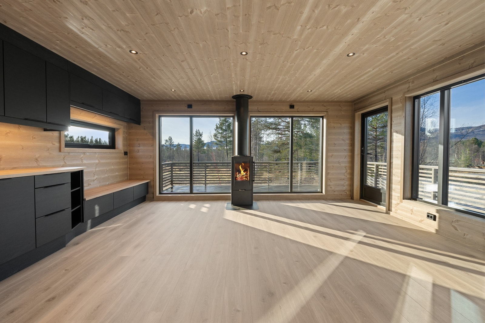 Stue med store vindusflater, flott utsikt, peisovn og utgang til solrik terrasse. Galleribilde