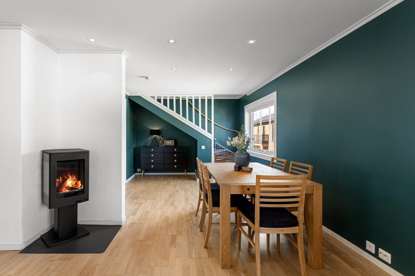 Mellom stue og spisestue finnes en stemningsfull peisovn, som sammen med varmepumpen sørger for god varme til etasjen. Galleribilde