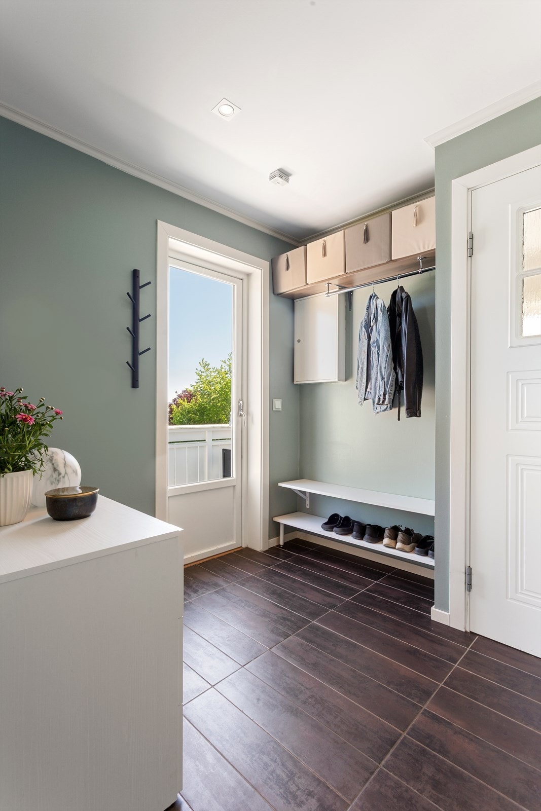 Velkommen inn! Lys og pen entré i 2. etasje med flislagt gulv, overflater malt i moderne fargetoner og utgang til veranda. Galleribilde