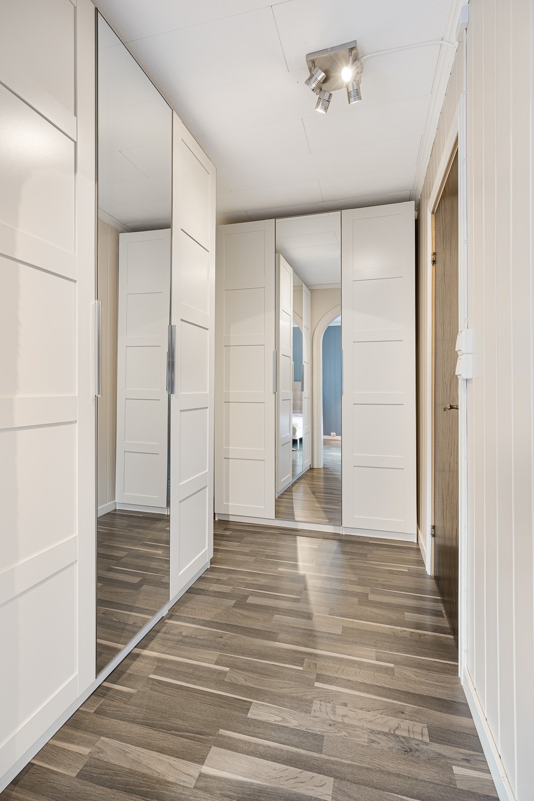 Det er laget bueåpning mot garderobedelen, hvor det er takhøye garderobeskap med hvite fronter og speil. Galleribilde