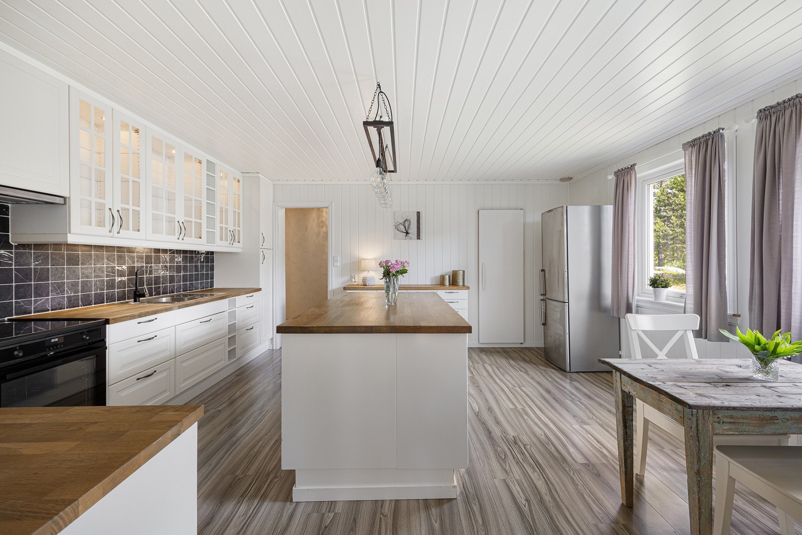 Kjøkkenet er et stort og luftig rom, slik et gårdskjøkken skal være, og utstyrt med en nyere innredning fra 2012. Denne er klassisk i stilen med takhøye skap, hvite, profilerte fronter, vitrineskap med belysning, rikelig med skapplass og en stor kjøkkenøy Galleribilde