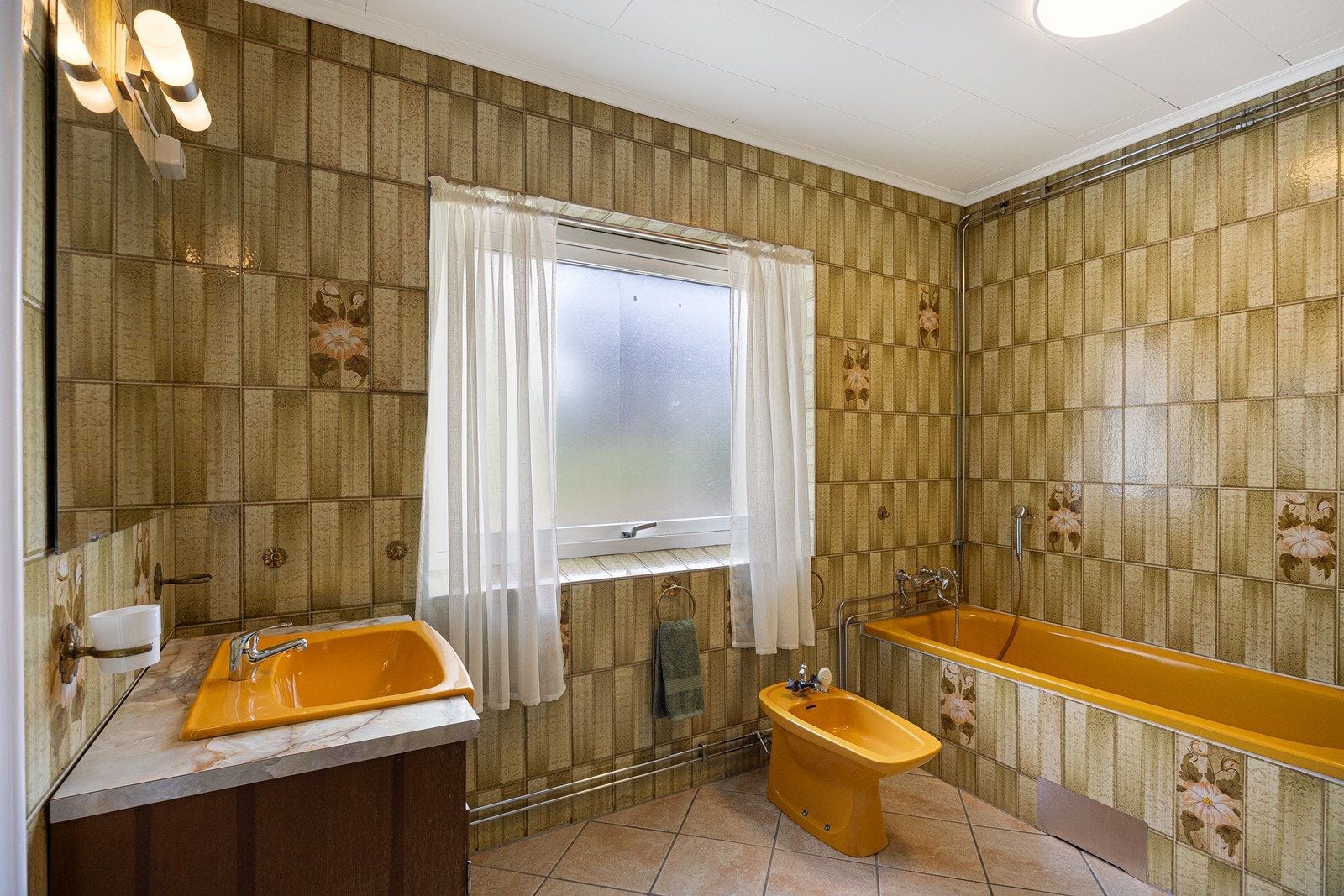 Bad i tilknytning til hovedsoverommet i 1. etasje. Badet har overflater og innredninger som mest sannsynlig er fra 1970-80-tallet. Galleribilde