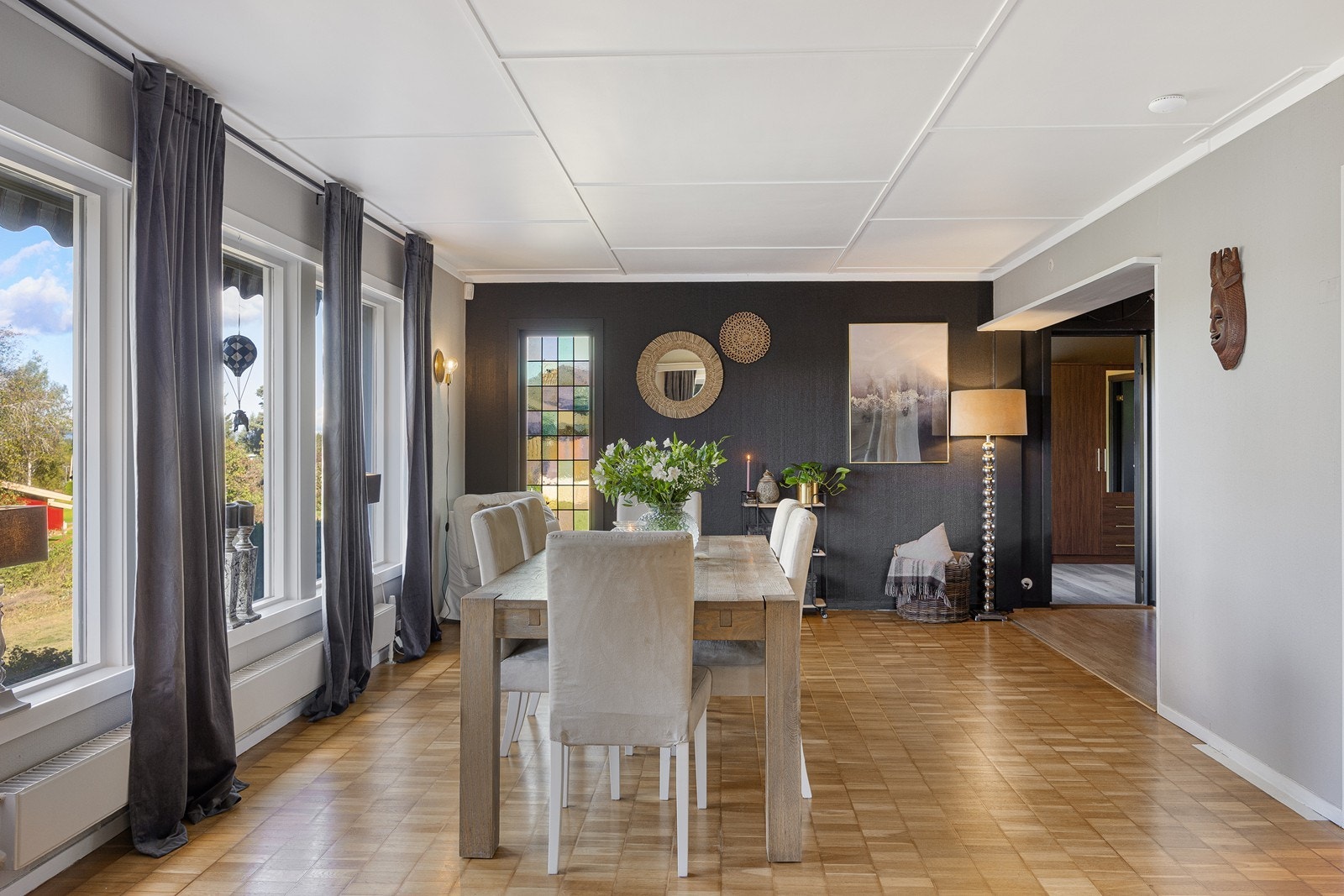 I den sortmalte endeveggen er det et fargerikt blyglassvindu. Stuene har ellers gråmalte vegger mot gyllent gulv. Galleribilde