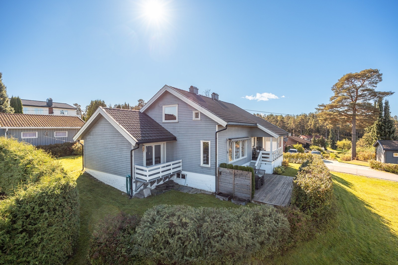 Tomten er pent opparbeidet med gressplen, gruslagt gårdsplass, prydbusker og vakre bed, og hagen rammes inn med tett, velfrisert hekk. Galleribilde