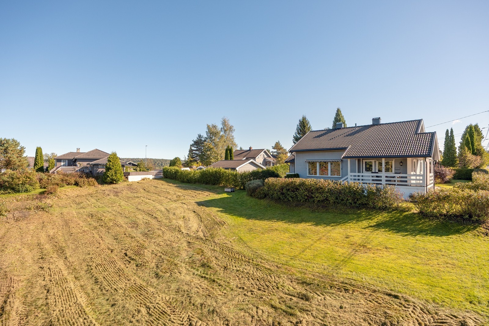 Tilstøtende og ubebygde tomt mot vest (bakerst mot nabohus i bildet) kan kjøpes i tillegg hvis ønskelig og etter særskilt avtale. Tomten har et areal på på 715 kvm. Galleribilde