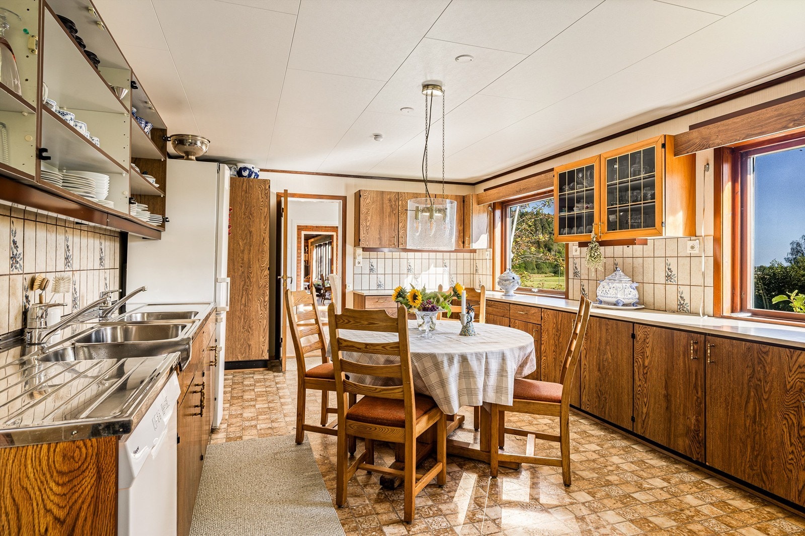 Kjøkkenet er så romslig at hele familien kan bli med å lage mat! Innredningen omkranser spiseplassen, en naturlig samlingsplass i rommet. Mellom benk og overskap er det keramiske flis. Galleribilde