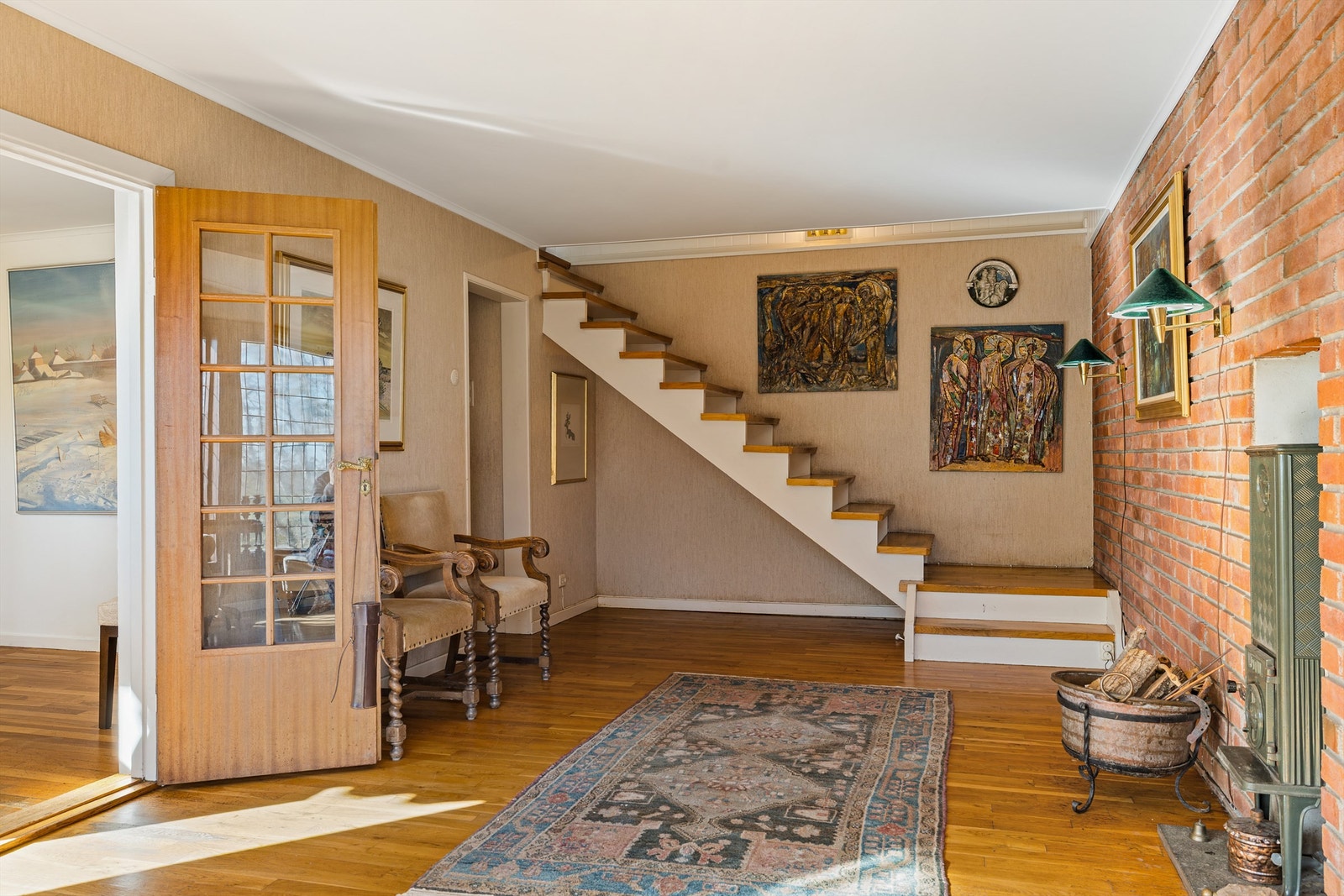 I forstuen er det en fondvegg i teglstein og nisje med vedovn,- nok et element som bidrar til retro stilen og viser solid håndverk. Galleribilde