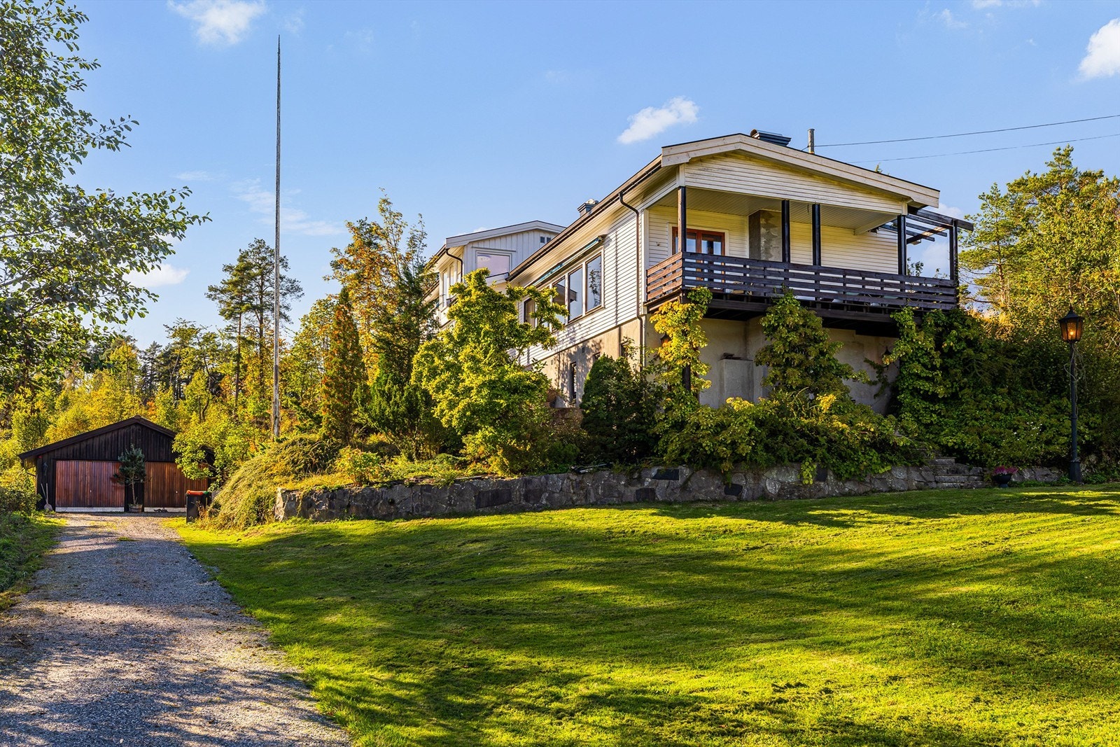 Huset ligger idyllisk til, omkranset av åkerlandskap og skog. Her er det stille, vakkert og fredelig. Panelet på gavlveggen er malt etter at bildet ble tatt. Galleribilde