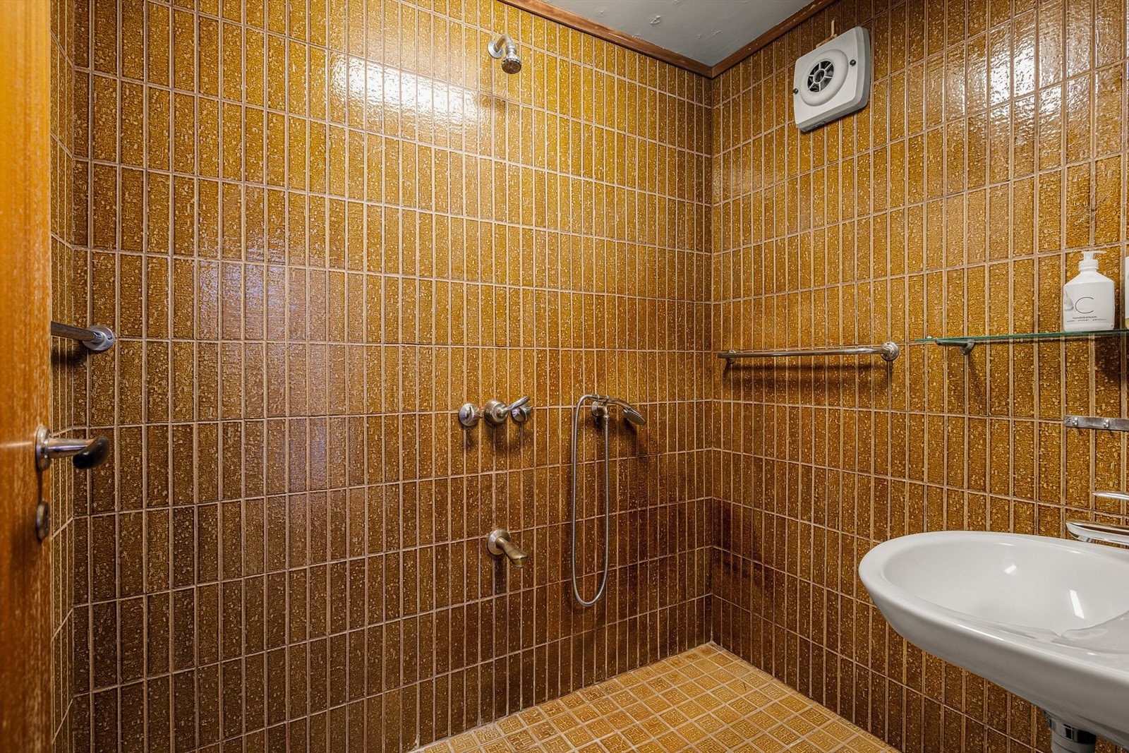 Badet i 1. etasje har også retrostil med karakteriske flis. Integrert dusjarmatur og servant. Galleribilde