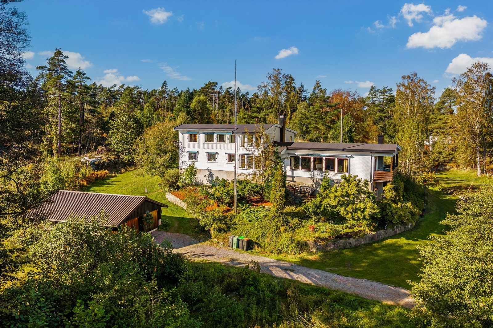 Huset er omsvøpet av vakre grønne trær og busker i rolige omgivelser. Galleribilde