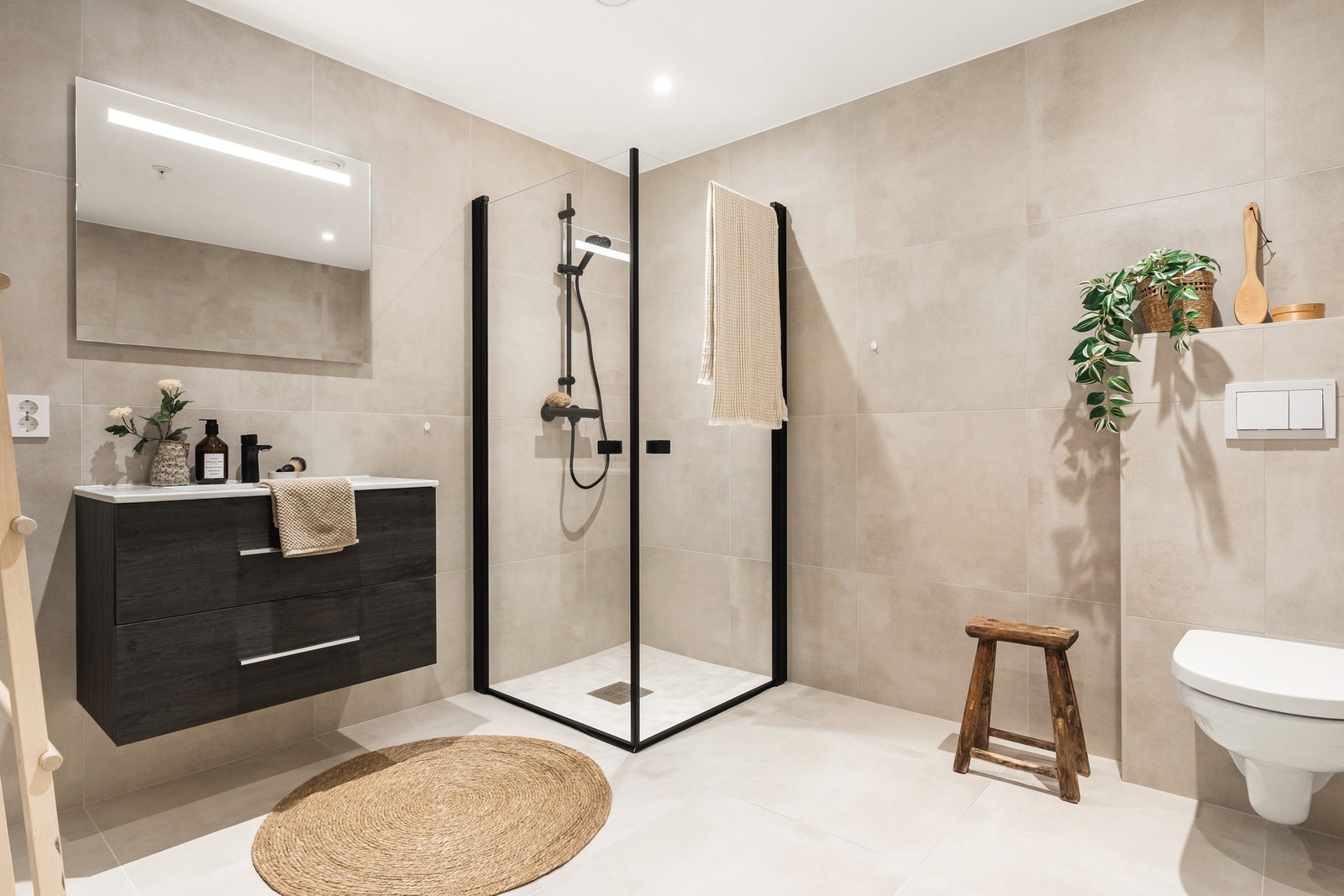 Hovedbadet har også en lekker utførelse med 60x60 fliser og sorte detaljer. Det er også spotlights i himling og varmekabler i gulv. Galleribilde