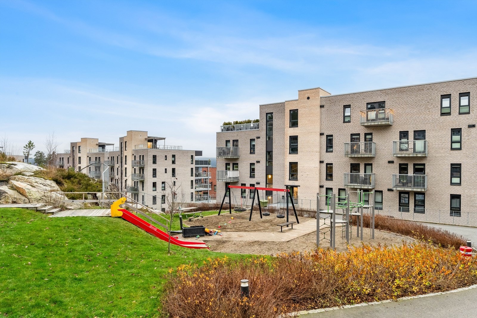 Blant det grønne er det uteplasser med tredekke, flere sittebenker, sandkasse og en stor lekeplass hvor barna fritt kan utfolde seg. Galleribilde