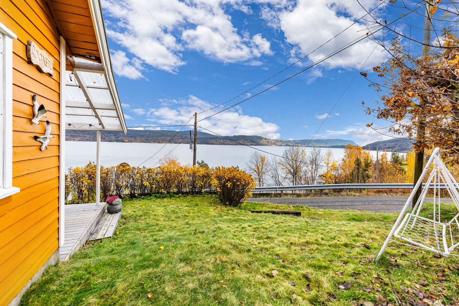 Tomten er pent opparbeidet med gressplen og busker. Galleribilde