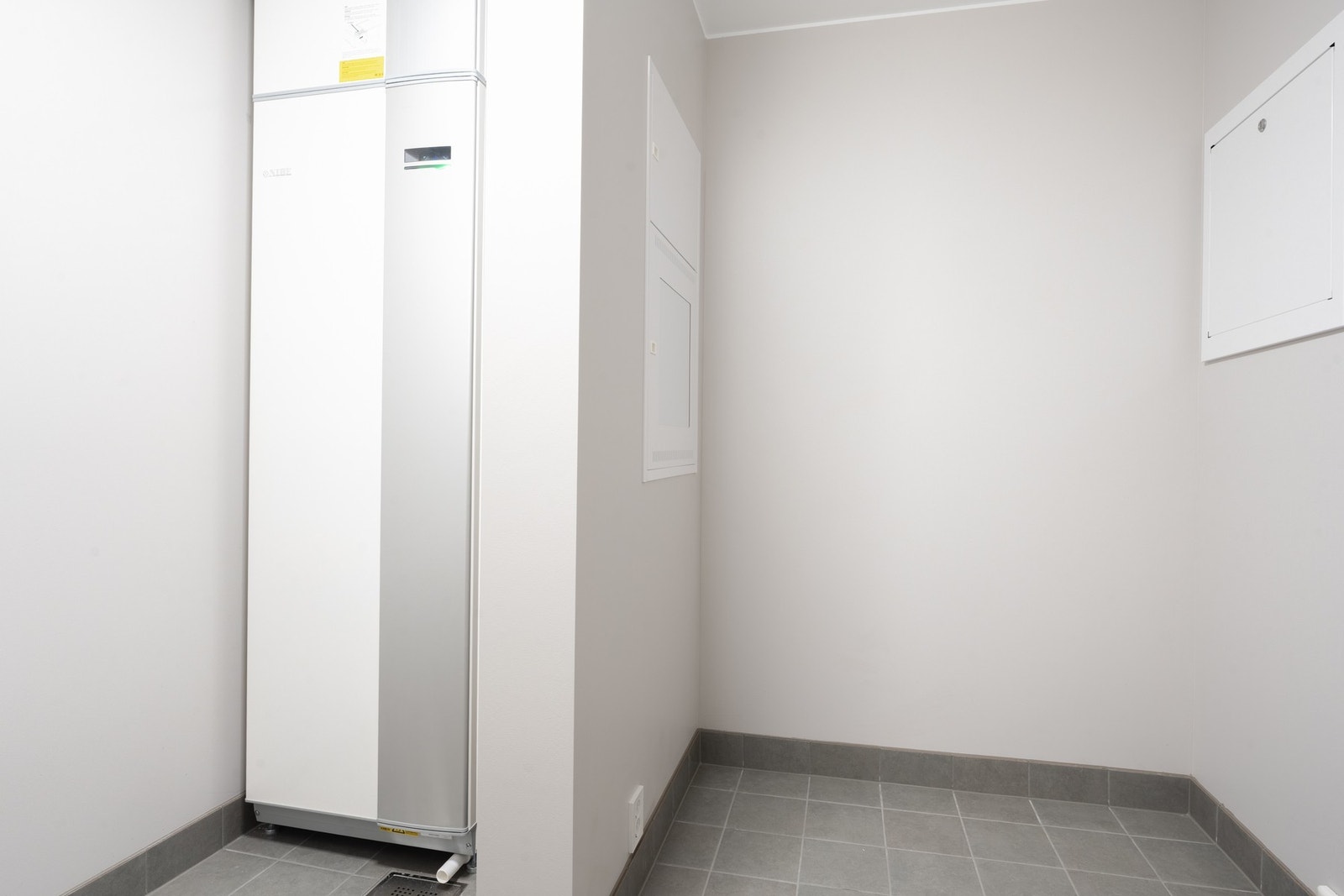 Vaskerommet er fliselagt på gulv og har opplegg for vaskemaskin, plass til tørketrommel og eventuell innredning som skap, benkeplate eller andre oppbevaringsløsninger. Galleribilde