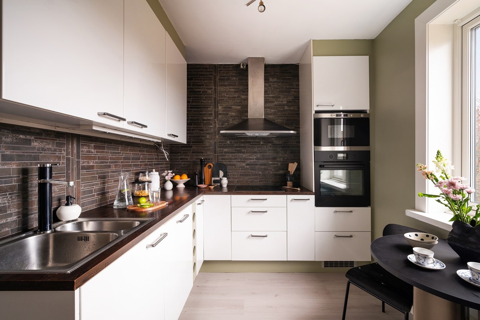 Innredningen er fra IKEA med lyse, glatte fronter og laminat benkeplate med oppvaskkum og ett-greps svingbart blandebatteri. Galleribilde