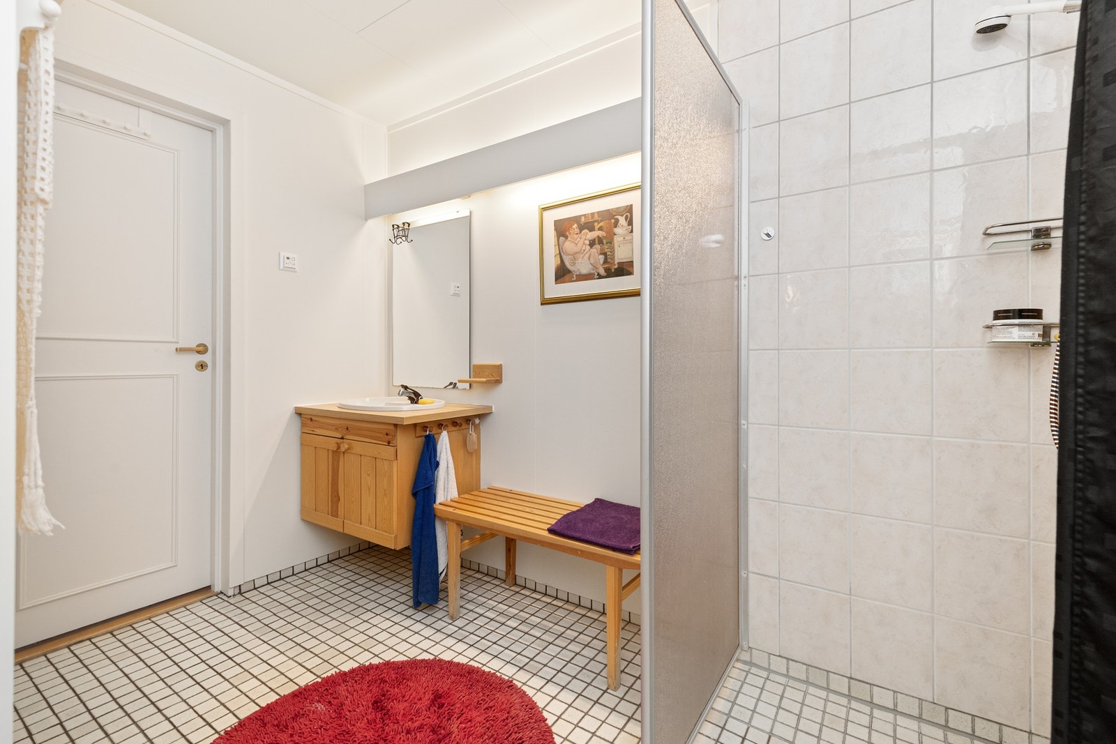 Innredning med heltre fronter, laminat benkeplate og speil. Toalett, nedfelt servant og dusjnisje/hjørne med glassdører Galleribilde