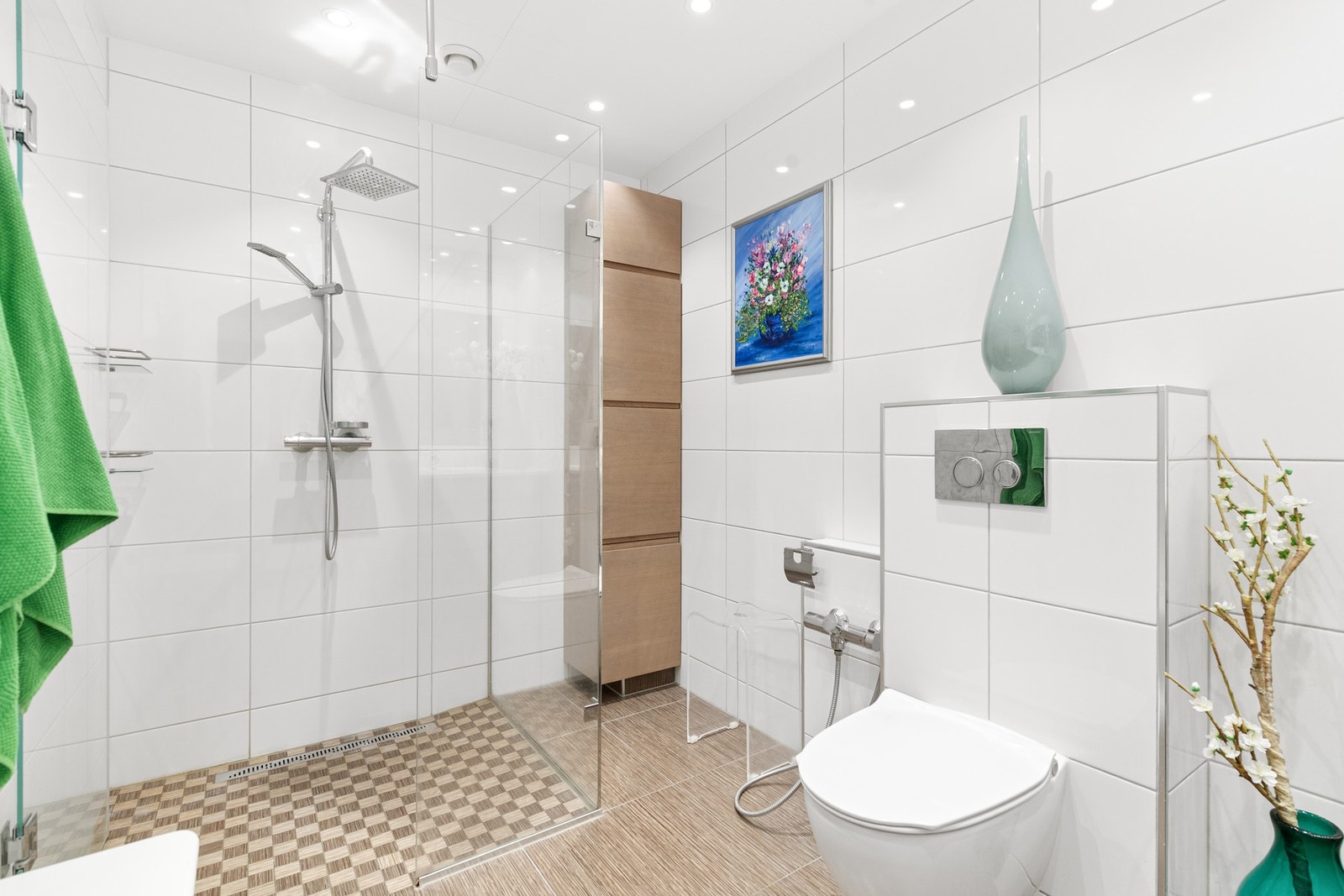 Veggmontert toalett og dusjhjørne med glassdører. Skittentøysjakt er etablert i nedre del av høyskap og fører ned til teknisk rom/vaskerom Galleribilde