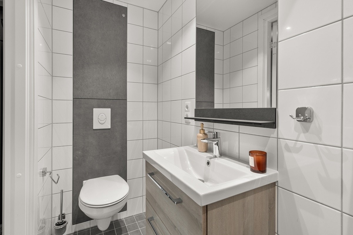 Badene er flislagt, og innredet med moderne servant i tillegg til toalett og dusj Galleribilde