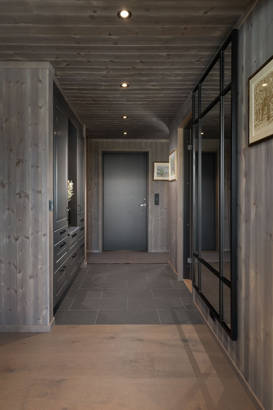 Velkommen inn! Praktisk entré og gang med fliser og varmekabler på gulv, og gode garderobeløsninger i tilpasset innredning. Galleribilde