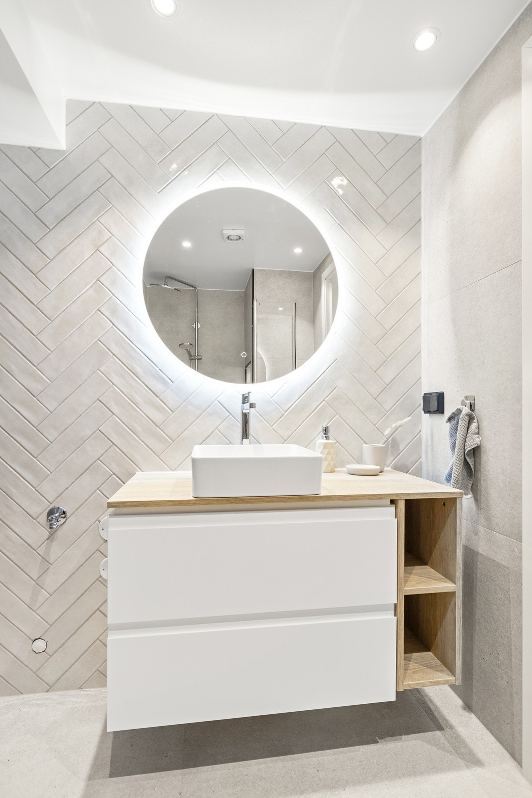 Badet innehar vegghengt toalett, servant med skuffer og dusjnisje med innfellbare glassdører. Galleribilde