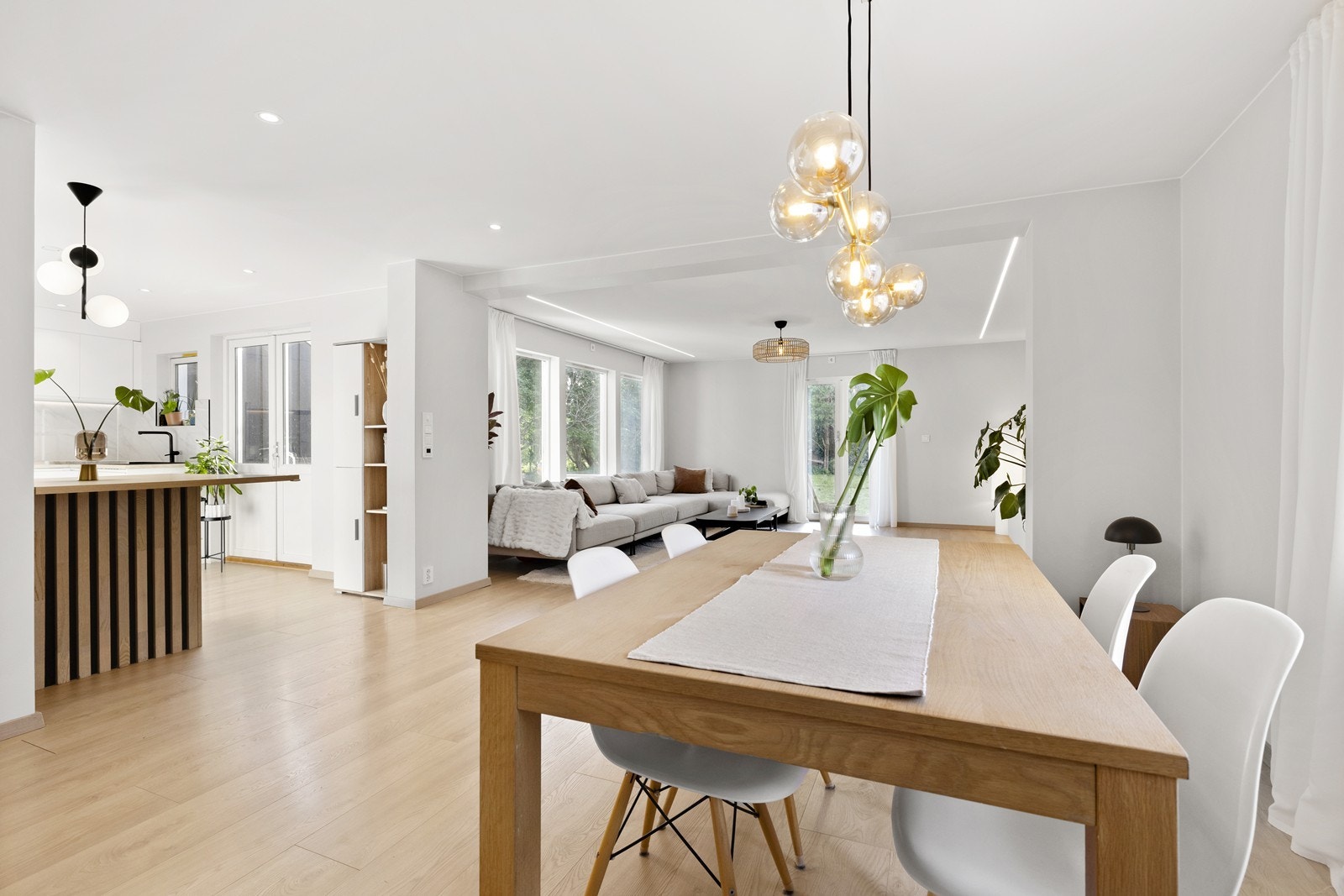 Spisestue med moderne belysning og nærhet til kjøkkenet for enkel servering. Galleribilde