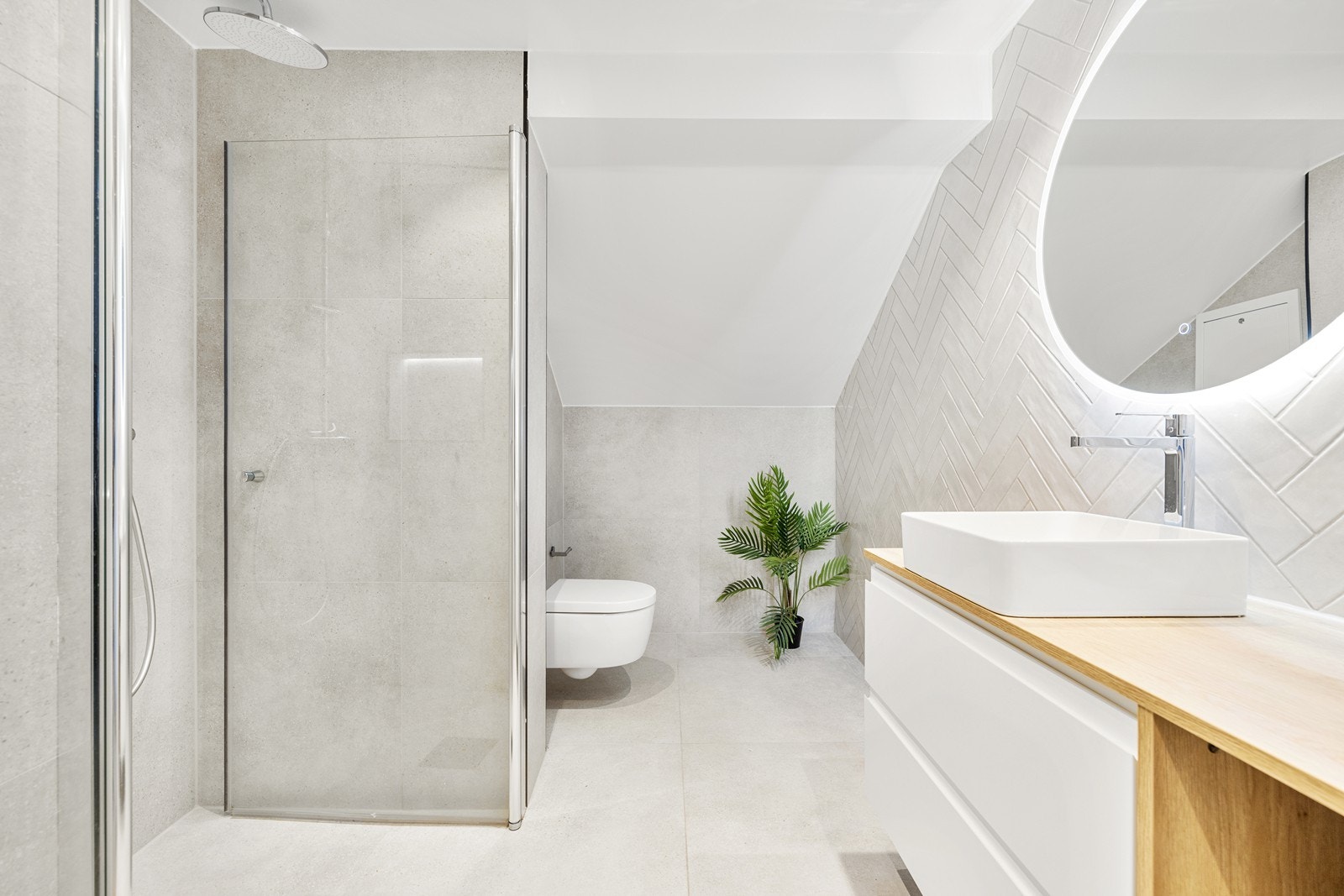 Baderom med moderne uttrykk og flislagte overflater. Galleribilde