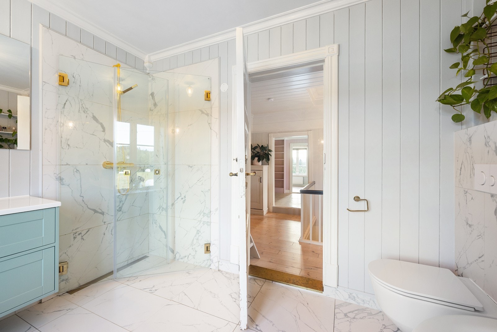 Stilrent dusjhjørne med gullfargende detaljer og innfellbare glassdører. Galleribilde