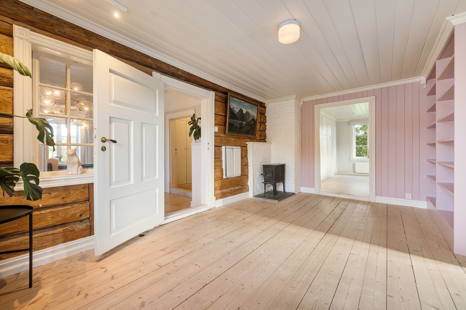 Bibliotek/loftstue med vedovn. Bokhylle i biblioteket er bygget av Krestensrud innredning. Galleribilde