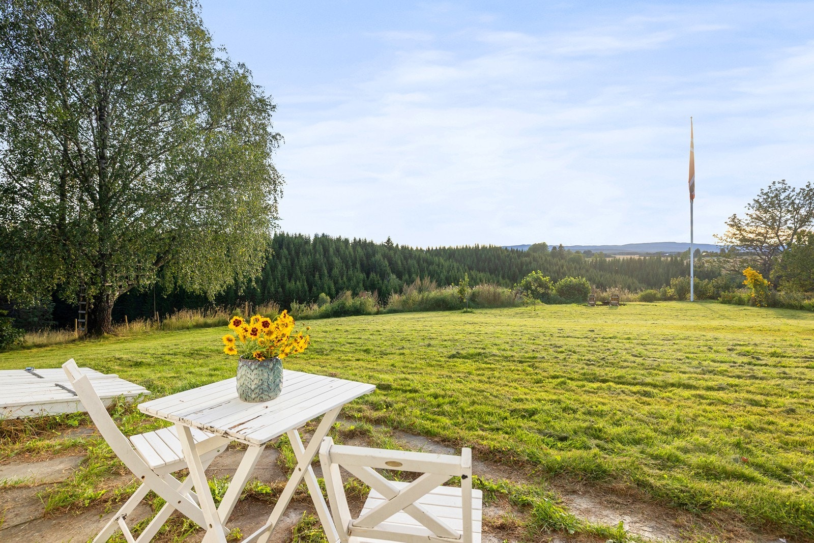 Koselig hage med med steinbelagt uteplass ved bolighuset. Her har du plass til utemøblement. Galleribilde