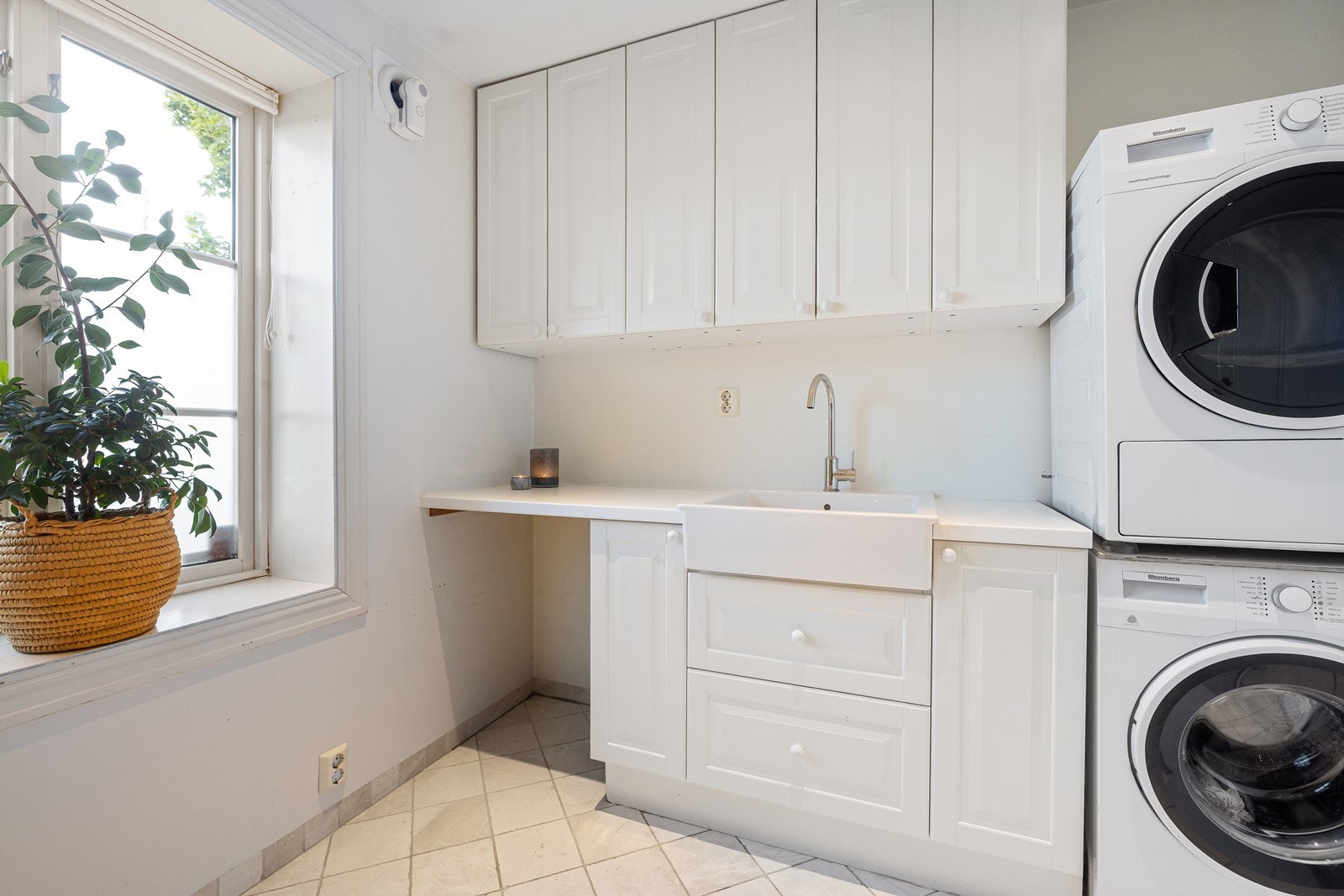 Videre er det servant i benkeinnredning med overskap, og opplegg for vaskemaskin og tørketrommel. Galleribilde