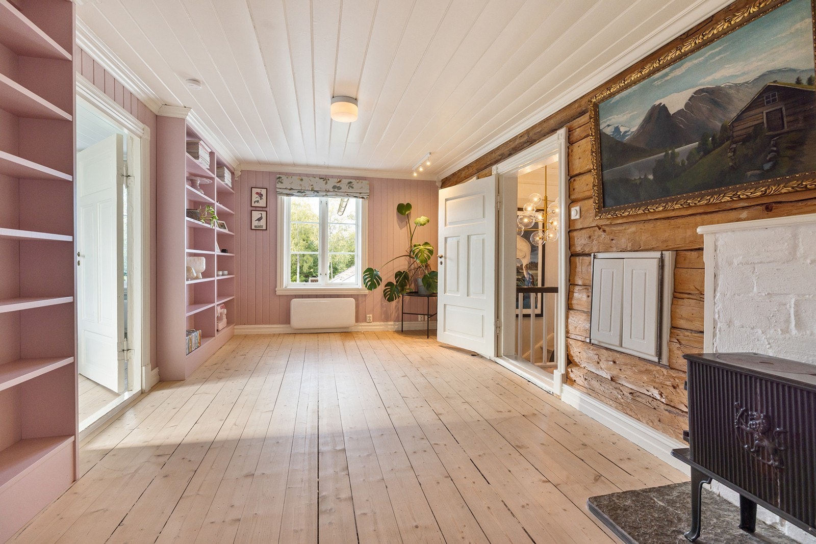 Loftstue/bibliotek med plassbygde bokhyller. Galleribilde