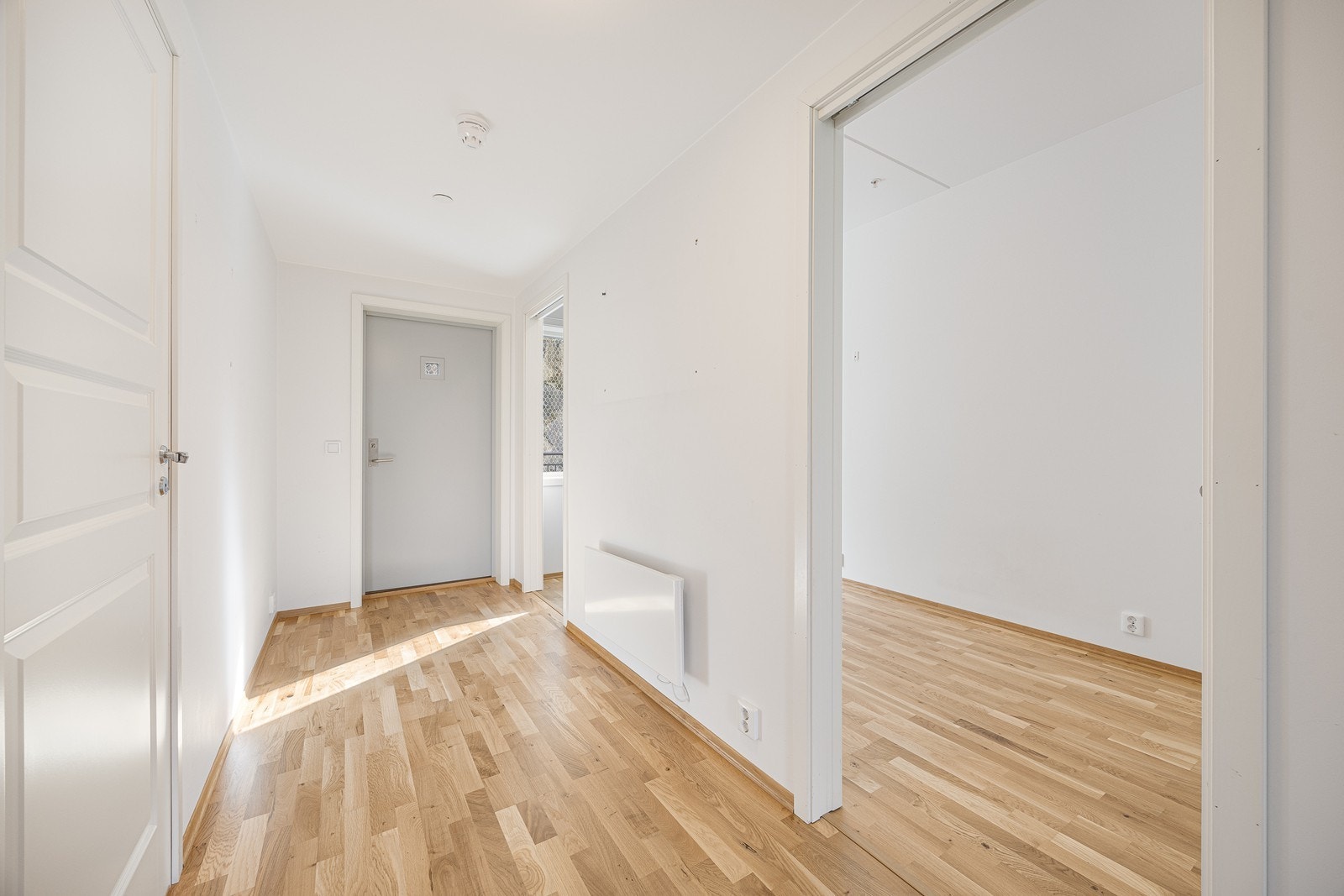 Leiligheten har hvitmalte, glatte vegger og parkett på gulvet i alle rom, med unntak av badet. Entreen har plass til garderobeløsninger. Galleribilde
