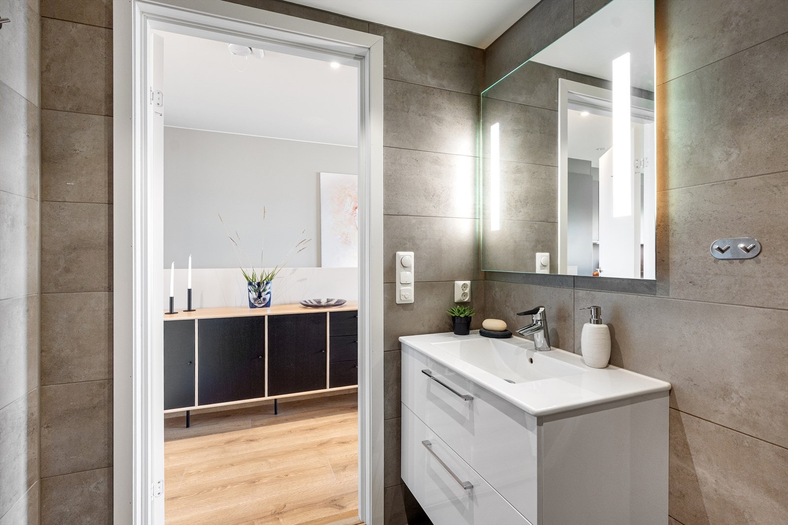 Servantskap med hvite høyglansfronter og keramisk servant med ettgreps blandebatteri. Galleribilde