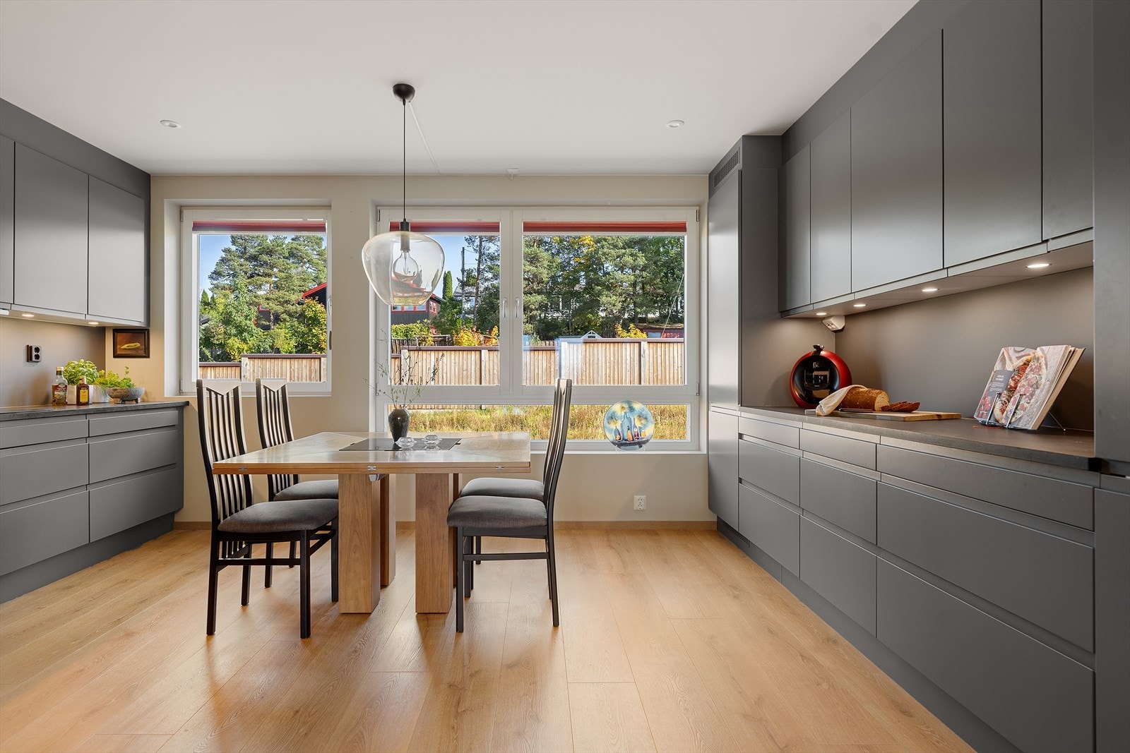 Rommet har god plass til spisebord og store vindusflater som slipper inn rikelig med dagslys. Ualminnelig god skapplass med blant annet et kolonialskap. Galleribilde