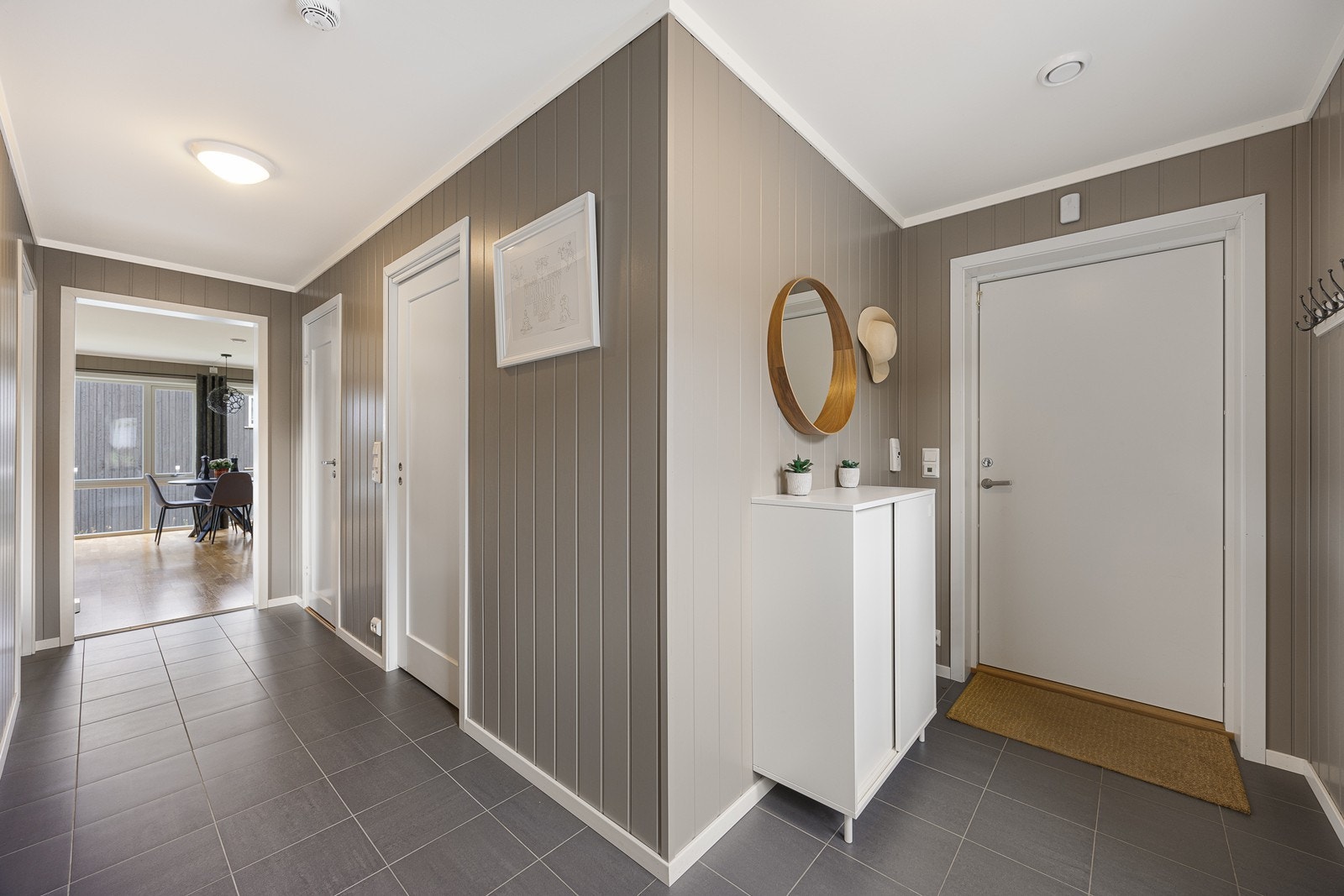 Entreen er et hyggelig rom å komme hjem til med flislagt gulv, veggpanel malt i gråfarge og varmekabler i gulv. Galleribilde