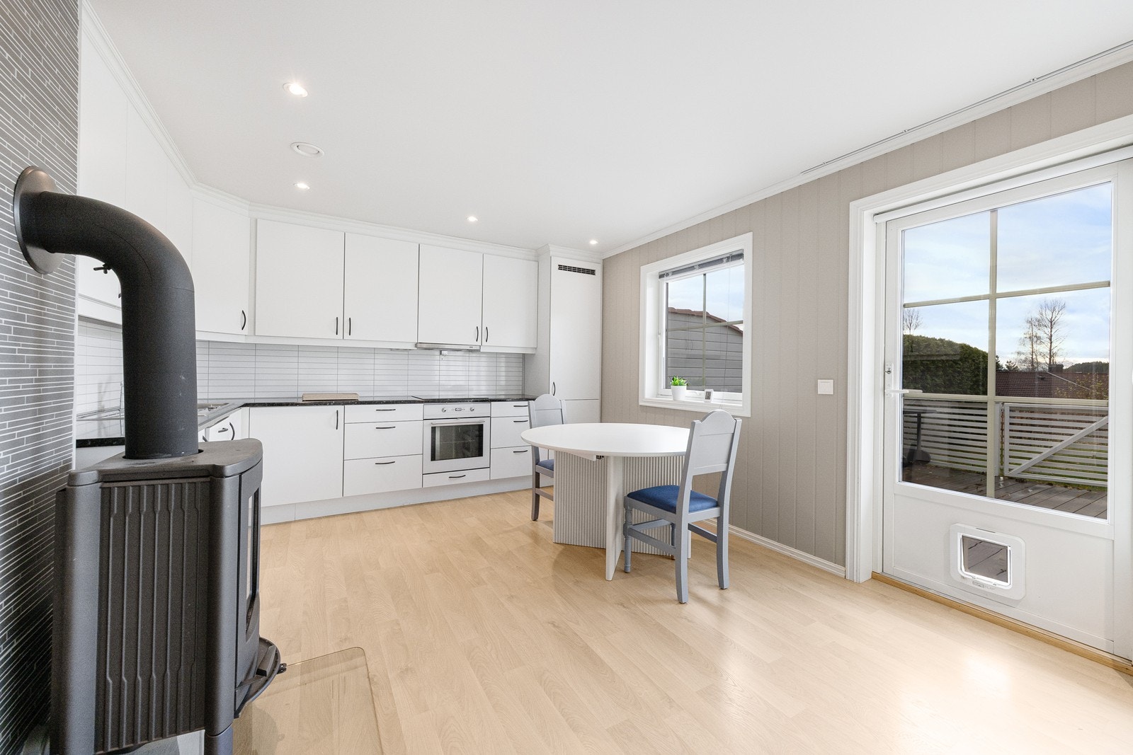 Kjøkkenet har en tidløs innredning med glatte fronter og en benkeplate i laminat. Galleribilde