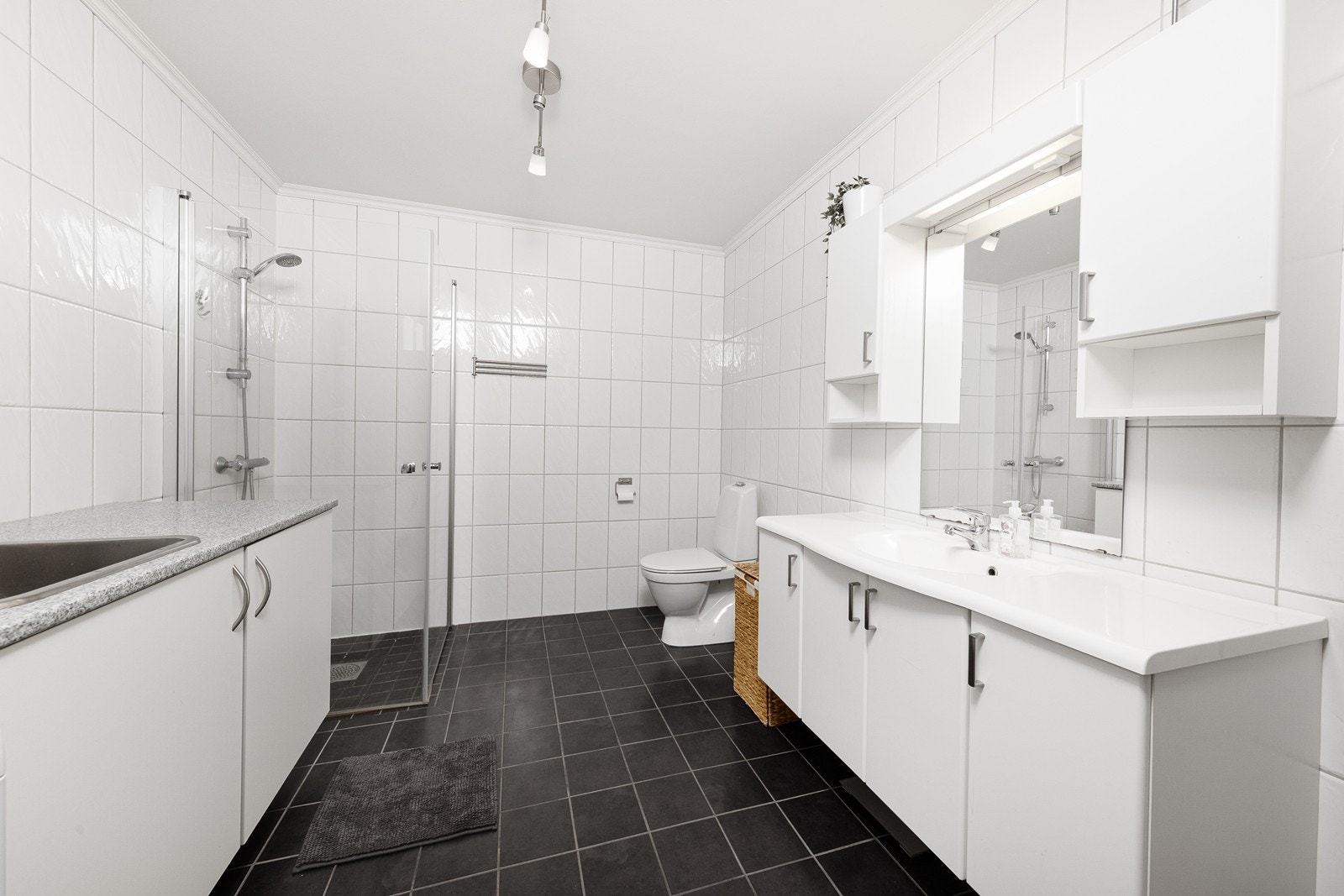 Badet er romslig og lyst innredet med baderomsinnredning, dusjhjørne, toalett og opplegg for vaskemaskin. Galleribilde