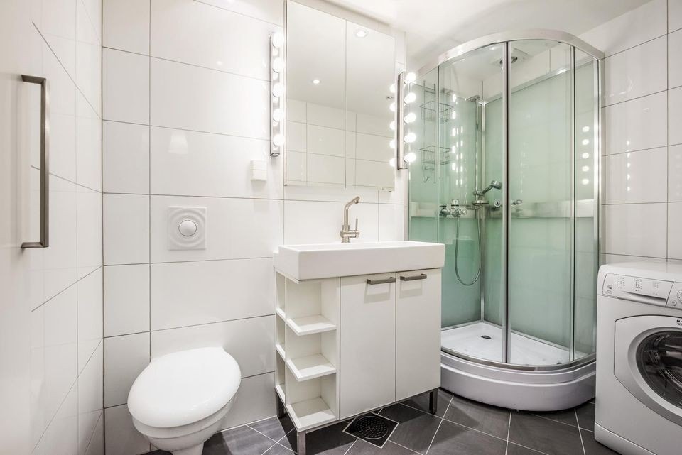 Romslig baderom med vaskemaskin og tørketrommel. Galleribilde