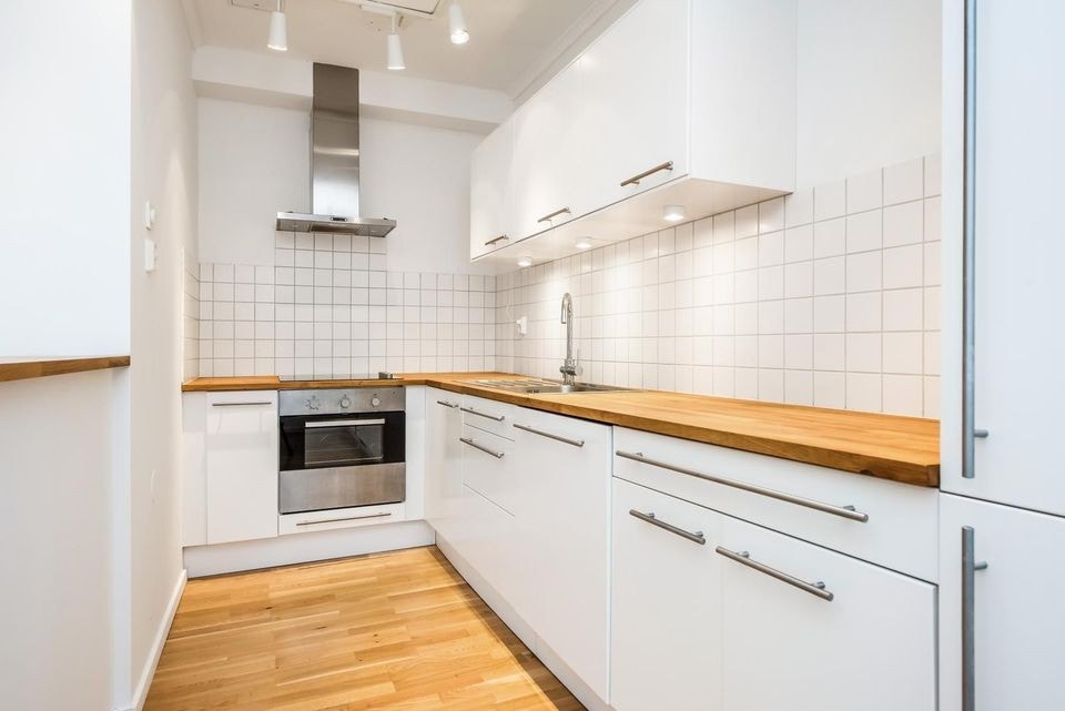 Moderne delvis åpen kjøkkenløsning med rikelig lagringsplass Galleribilde