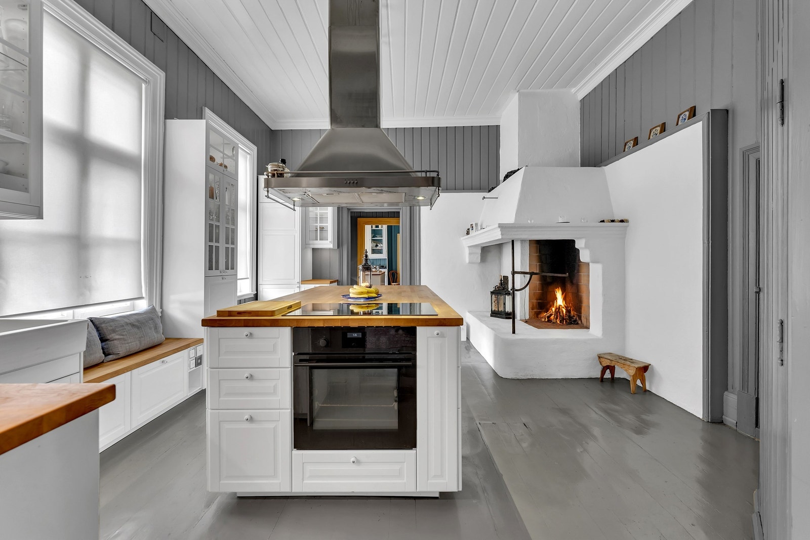 Nyere kjøkkeninnredning i elegant utførelse. Gruepeisen i hjørnet tilføyer rommet en rustikk og koselig atmosfære Galleribilde